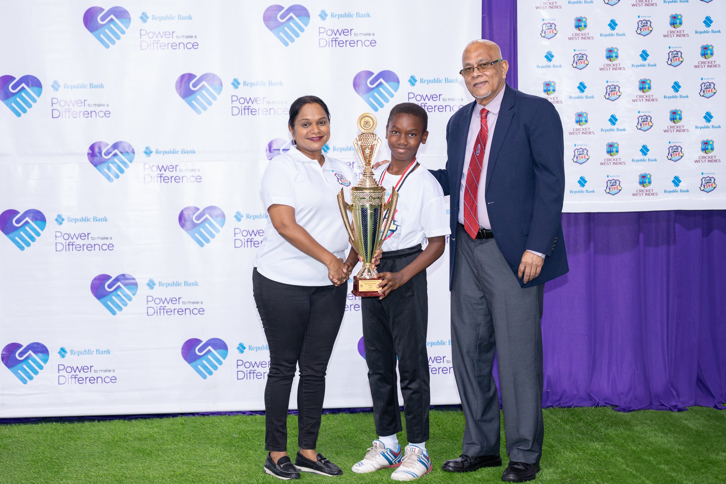 Photo 2- Longdenville Government Team Captain Lenuel Joseph collects the 1st place trophy from Mr. Azim Bassarath- CWI Vice President and TTCB President and Ms. Reena Gopaul Manager Group Brand Management of Republic Ban